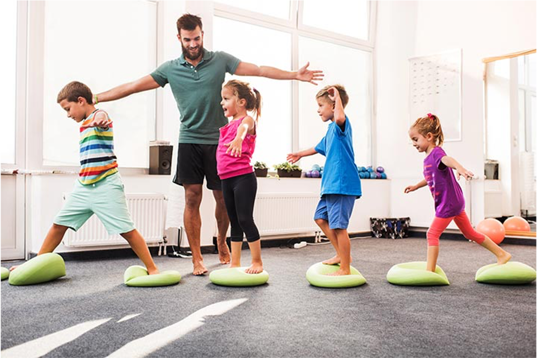 Kids with instructor on lime green small mats